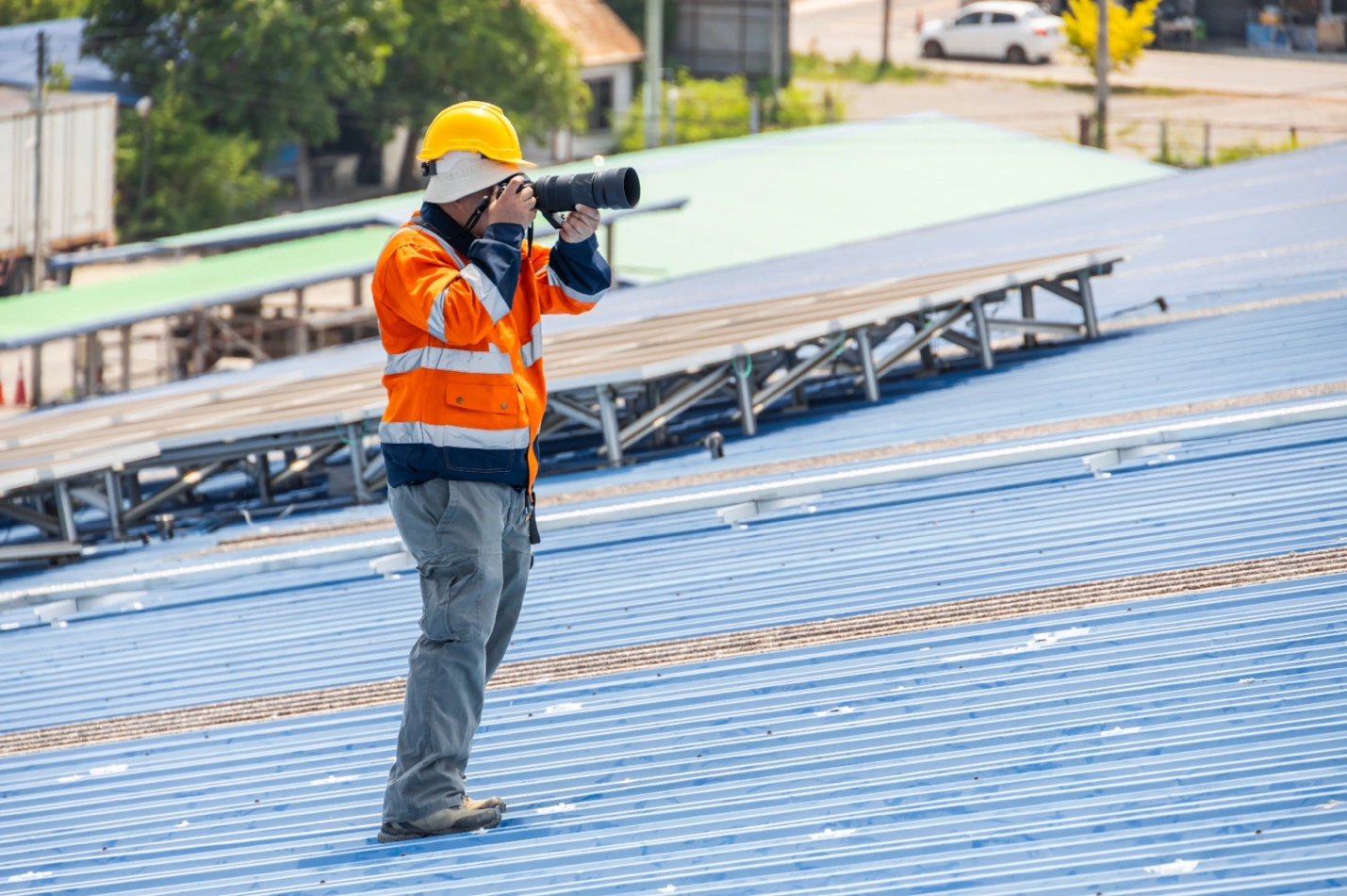 Worker using camera on solar panel roof, showcasing roofing advertising ideas for local lead generation